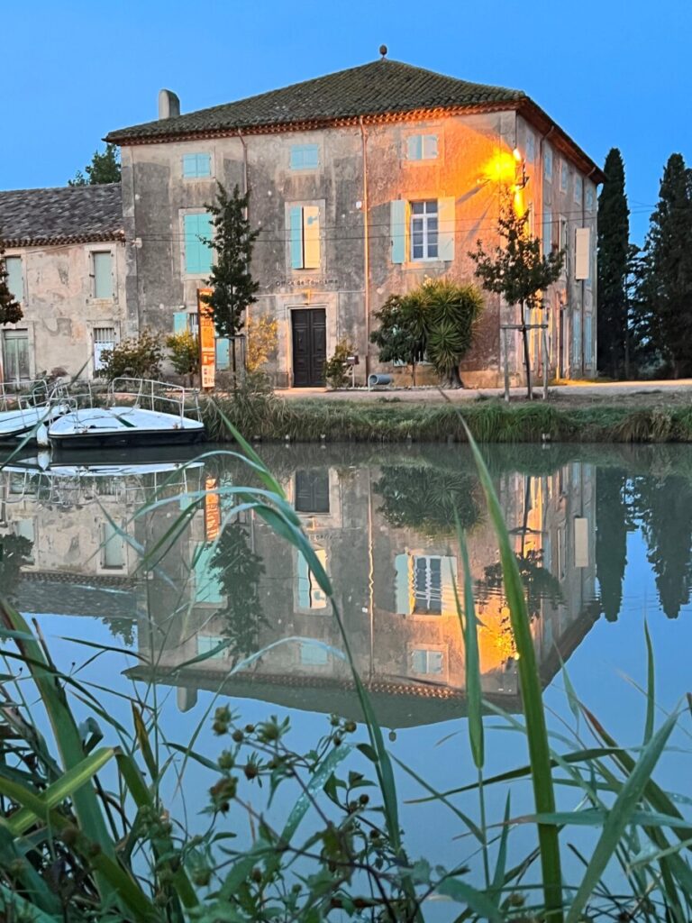 Turistkontoret i Le Somail reflekteres i vannet